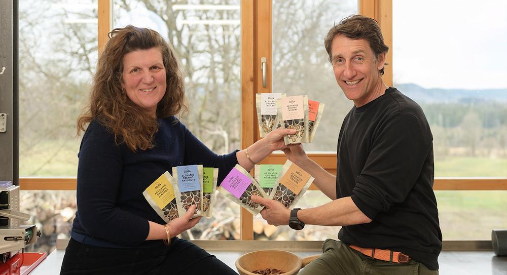 2die4 Live Foods team photo 2025 with staff holding organic activated nuts products